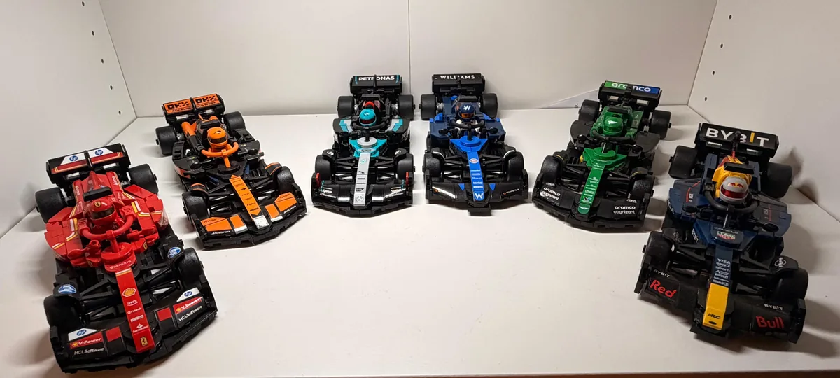 Seis autos de Fórmula 1 armados en Lego sobre una repisa: Ferrari, McLaren, Mercedes, Williams, Aston Martin y Red Bull