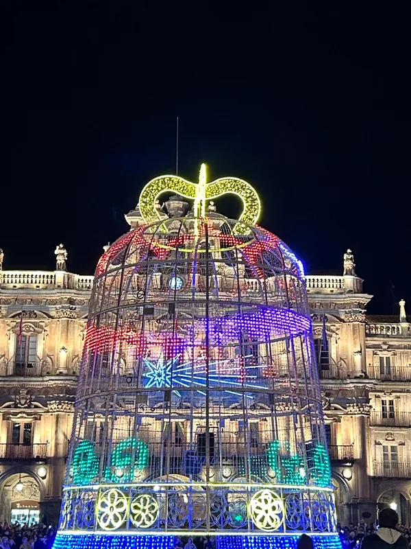 Plaza Mayor de Salamanca de noche, con una gran estructura de luces de colores frente a la fachada